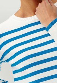 Weißer Pullover mit horizontalen blauen Streifen, ausgestattet mit einem gerippten Rundhalsausschnitt und Bündchen. Das Material wirkt glatt und leicht.
