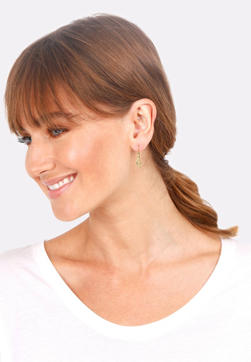Boucles d'oreilles pendantes en forme de note de musique en ton doré avec un design à crochet. Légères avec un motif délicat et intriqué.