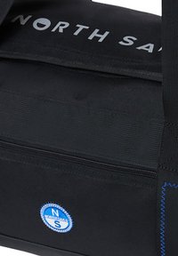 Borsa in tessuto nero con compartimento con cerniera, caratterizzata da testo bianco "NORTH SAILS," logo circolare blu e dettagli di cucitura evidenti.