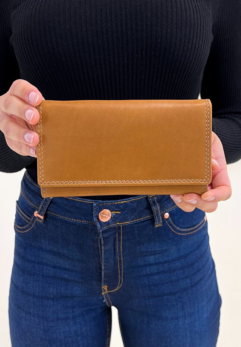Tan leren portefeuille met een gladde textuur en zichtbare stiksels, in handen gehouden. Heeft een rechthoekige vorm en een eenvoudig ontwerp.