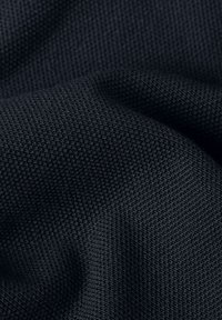 Tissu bleu marine foncé texturé avec un petit motif de maille serrée et des plis doux créant des ombres subtiles.