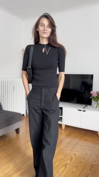 Melna pieguļoša blūze ar atslēgas caurumu, apvienota ar augstā vidukļa melnām biksēm. Vienkāršs dizains, gluda tekstūra un mūsdienīga silueta.