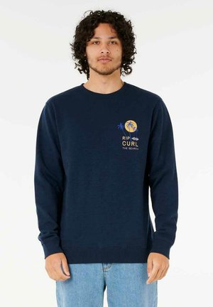 Marineblauer Pullover mit langen Ärmeln, gerippten Bündchen und Saum. Hat einen gelb-blauen Grafikdruck von Palmen und Text auf der Brust.