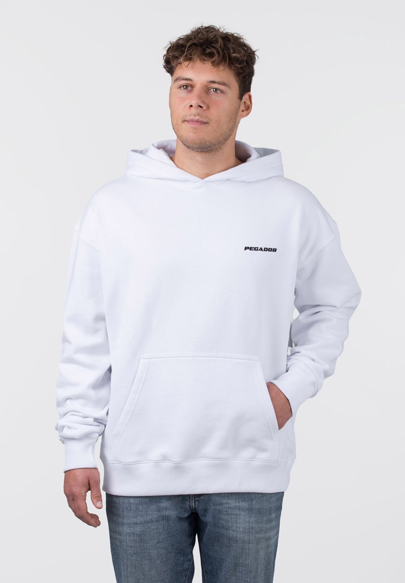 Weißer Baumwoll-Hoodie mit einer Fronttasche, der ein schwarzes "PEGADOR"-Logo trägt. Das Design umfasst eine geräumige Kapuze und gerippte Bündchen.