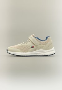 Μπεζ αθλητικό παπούτσι με ανώτερο μέρος από δίχτυ και συνθετικές λεπτομέρειες. Διαθέτει ιμάντα με γάντζο και βρόχο, υφασμένο πέλμα και μπλε λεπτομέρεια στο γιακά.