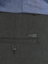 Crne hlače s teksturom i zatvaranjem na jedan gumb, s oznakom "JACK & JONES" na stražnjem džepu, u kombinaciji s plavom košuljom.