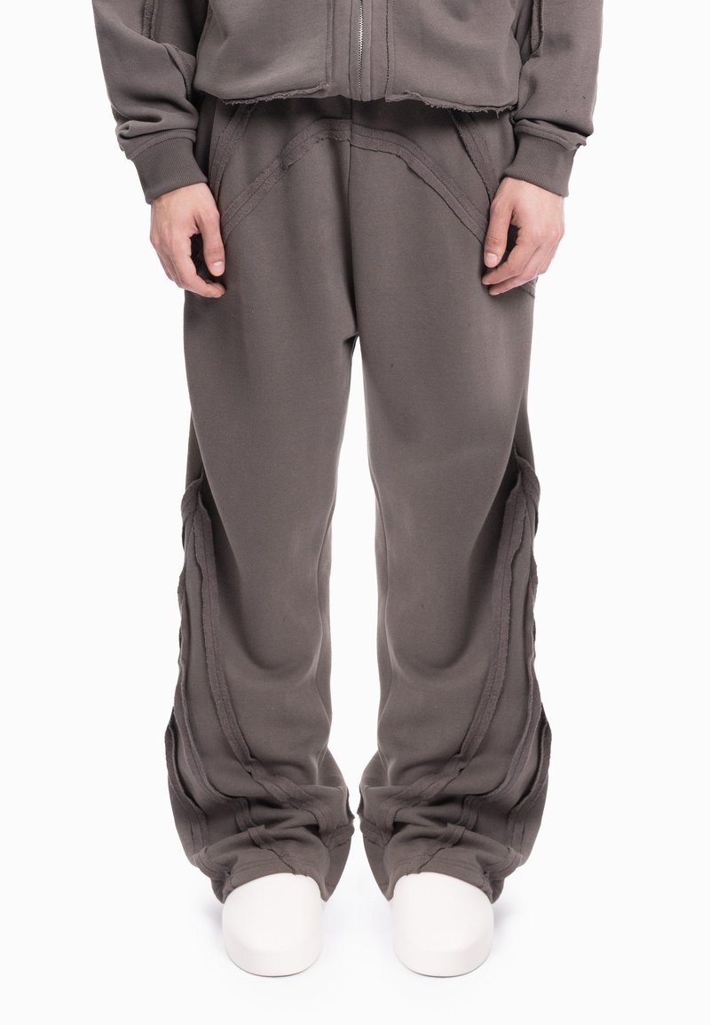 Grijze joggingbroek met een losse pasvorm, getextureerde naden en een gelaagde stofontwerp, met een lichte toelopende aansluitingen bij de boorden.