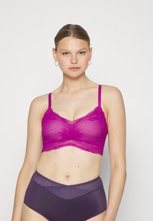 Lyserød blonde bralette med bølget kant og tynde justerbare stropper, parret med høj-taljede semi-gennemsigtige lilla trusser.