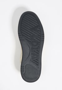 Suela de zapato de goma negra con patrón de agarre texturizado; presenta el logo de la marca en relieve "YOLA" y elementos de diseño curvados.