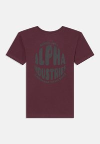 T-shirt de algodão cor vinho com uma grande estampa em cinza escuro a dizer "ALPHA INDUSTRIES" e "SINCE 1959" num design circular na parte de trás.