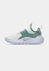 Nike tenisica s gornjim dijelom od svijetlozelene tkanine, ljubičastim detaljima i elastičnom trakicom. Ima debeli bijeli potplat s natpisom brenda.