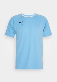 Camisa deportiva de manga corta en azul claro, hecha de un tejido suave, con un cuello blanco y un logo de Puma en navy en el pecho.