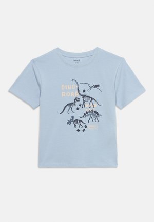 Light blue short-sleeve child's t-shirt with dark dinosaur skeleton prints and text reading "Dino Roar" and "Dangerous Giant."