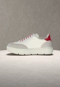 Λευκό και γκρι αθλητικό παπούτσι με κόκκινη φτέρνα και κορδόνια με κόκκινες λεπτομέρειες, παχύ πάτο και διακριτική σήμανση "LOVE MOSCHINO" στο πλάι.