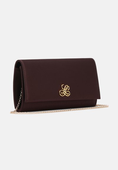 Pochette en cuir marron foncé avec un monogramme décoratif doré sur le devant et une fine chaîne dorée sur fond blanc.