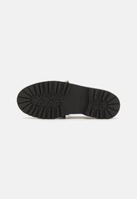 Talpa de cauciuc negru cu un model de profil, featuring șanțuri texturate și stele, oferind aderență și durabilitate.