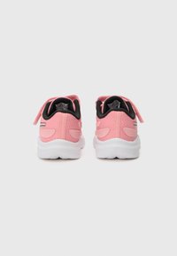 Baskets de sport roses avec une tige en mesh et synthétique, accents noirs, brides Velcro et une semelle en caoutchouc blanche.