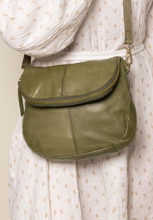 Olive green leather crossbody bag with a rounded shape, zip closure, and a flap. Features gold-tone hardware and a textured finish.
