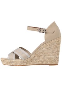 Beige wedge sandaal met zilvergestreepte stoffen banden en enkelgesp. Jute-wikkelde middenzool met gestructureerd oppervlak. Gesloten achterkant ontwerp.