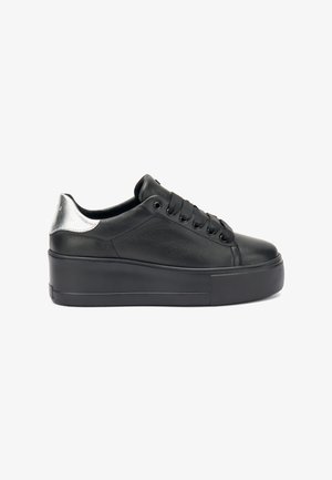 Zapatillas negras tipo plataforma hechas de cuero con una textura lisa, que cuentan con un acento metálico plateado en el talón y cordones negros.