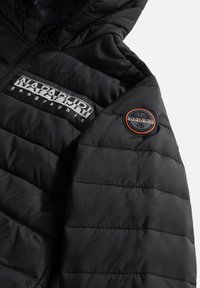 Veste noire matelassée avec fermeture éclair, logo Napapijri Geographic sur la poitrine et patch circulaire Napapijri sur la manche supérieure.