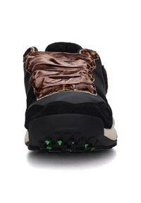 Sneaker nera con dettagli leopardati, lacci larghi in velluto mauve e una suola spessa con evidenziature verdi.