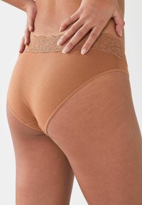 Lichte katoenen slips met een delicate kanten tailleband, met een gladde textuur en een klassieke snit, die comfort en pasvorm benadrukken.