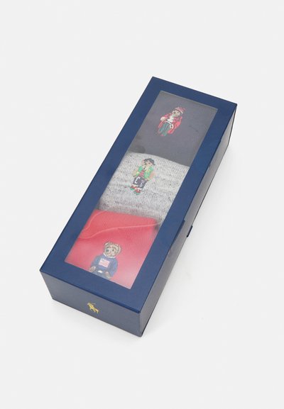 Boxed set of three socks. Colors: navy, gray, red. Each sock features distinct embroidered characters. Material appears knit with soft texture.