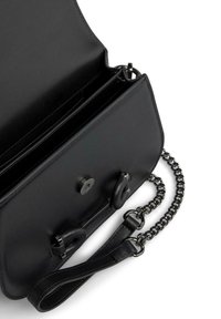 Borsa a mano in pelle nera con una superficie liscia, una tracolla a catena e una chiusura magnetica. All'interno presenta più scomparti per l'organizzazione.