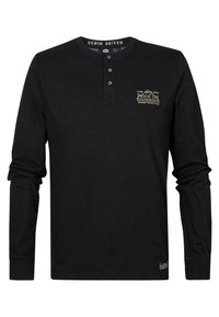 Musta pitkähihainen henley-paita, joka on valmistettu pehmeästä kankaasta. Paidassa on kolme nappia kauluksessa, rintatikkaukset ja kontrastiväriset saumat.