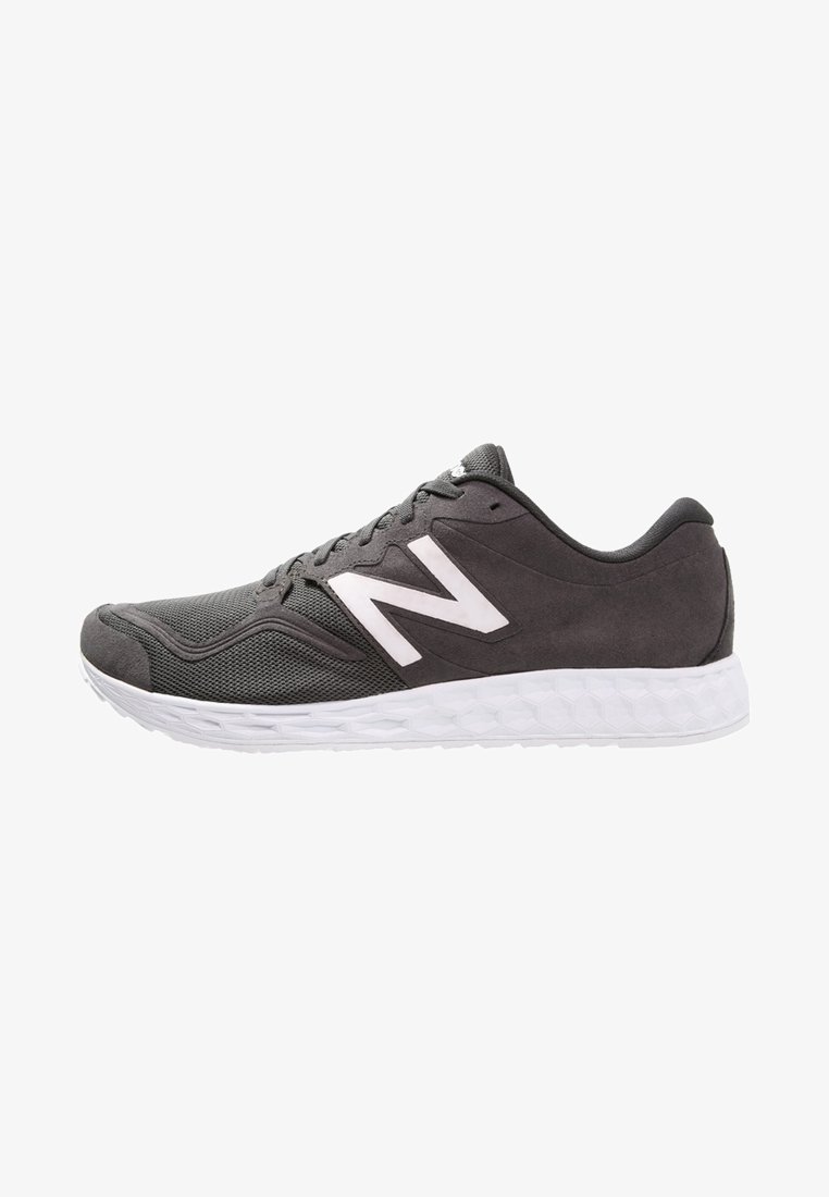 Chaussure de course New Balance gris foncé avec logo "N" blanc, avant en mesh respirant, côtés en suédé et semelle blanche texturée.