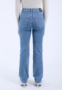 Light blue high-waisted jeans with a straight leg design, featuring two back pockets and visible stitching details.