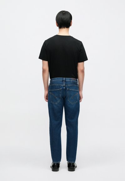 T-shirt noir et jean bleu en denim vus de dos. Le jean comporte deux poches arrière et une coupe droite, avec des coutures minimales.