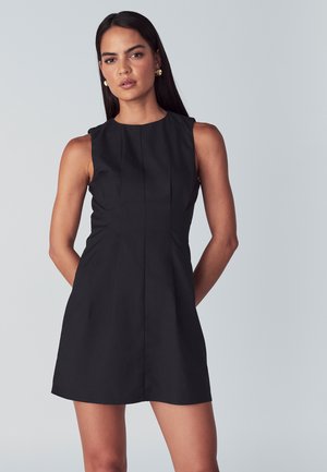 Mekko ilman hihoja, jossa on istuva bodice, pyöreä pääntie ja pleat-yksityiskohtia. Silkkinen kankaan pinta, polveen ulottuva helma. Yksinkertainen muotoilu.