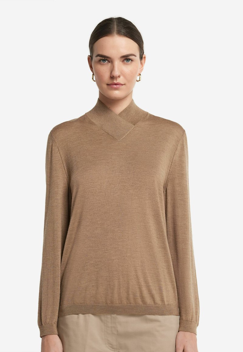 Brun långärmad topp med en hög, vikbar krage och ribbade ärmslut. Tyget verkar mjukt och lätt med en subtil glans.