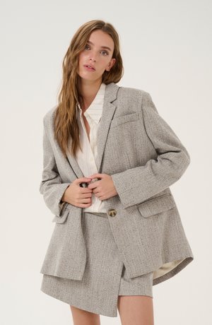 Grå herringbone blazer med to forlommer, enkelt knaplukning og opnåede ærmer, parret med en matchende nederdel. Tekstureret stof, skræddersyet pasform.