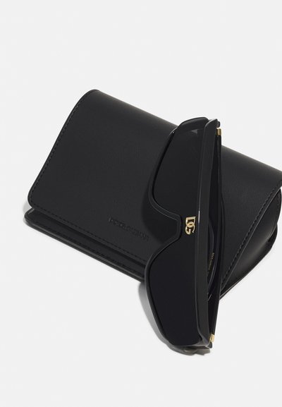 Occhiali da sole neri dal design elegante con dettagli dorati. Include un astuccio in pelle nera abbinato con logo impresso.