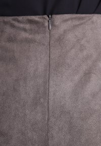 Grauer Kunstsuede-Rock mit glatter Textur, der einen Reißverschluss auf der Rückseite und ein einfaches, gerades Design aufweist.