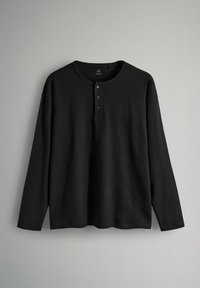 Camisa negra de manga larga con cuello redondo y tapeta de tres botones; tela suave con corte relajado y aberturas laterales en el dobladillo.