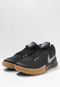 Et par sorte Nike Zoom Live basketballsko med tekstureret overdel og gummigummi såler, præsenteret på en hvid overflade.