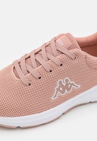 Vaaleanpunaiset verkkomateriaalista valmistetut lenkkarit, joissa on litteät nauhat, teksturoitu pinta, valkoinen pohja ja valkoinen Kappa-logo. Pyöristetty kärki ja hengittävä muotoilu.