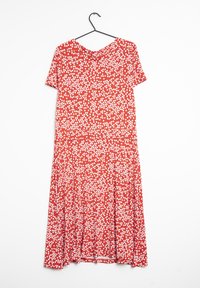 Robe rouge à pois blancs, à manches courtes, décolleté en V et jupe évasée. Fabriquée en tissu doux avec une texture lisse. Accrochée à un crochet.