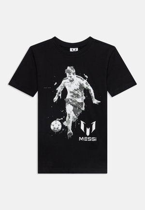 Sort T-shirt med et gråtonebillede af en fodboldspiller, der sparker til en bold, og teksten "MESSI" under billedet.