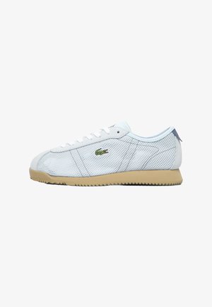 Zapatillas de malla azul claro con suela de goma beige, cordones blancos y detalle del logo en verde. Presentan una puntera redonda y paneles laterales texturizados.