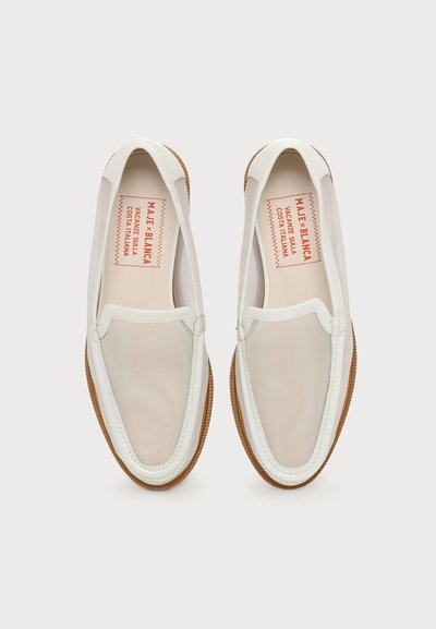 Paire de mocassins blancs à enfiler avec dessus en mesh beige et semelles en caoutchouc marron, vue de dessus sur un fond uni.