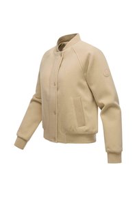 Veste bomber beige en tissu doux, dotée d'un col côtelé, de poignets côtelés et d'une poche frontale texturée. Comprend une fermeture à boutons-pression.