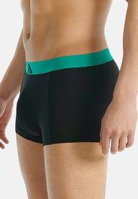 Svarta boxerkalsonger med en teal elastisk midja som har en strukturerad yta och logodetaljer. Designade för en åtsittande passform.