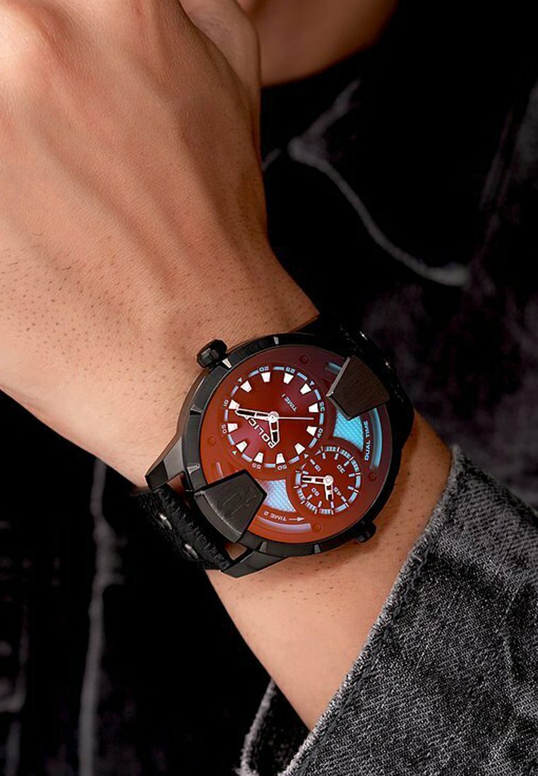 Montre analogique avec un cadran rouge et un boîtier noir. Dispose de plusieurs sous-cadrans et d'accents lumineux. Attache à un bracelet texturé noir.