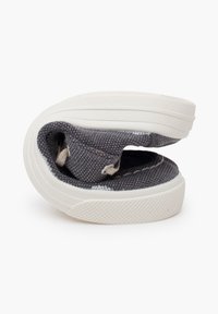 Graue Canvas-Schuhe mit einer flexiblen, konturierten Sohle und einer weißen Gummisohle. Verfügt über sichtbare Nähte und ein Slip-On-Design.