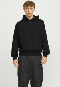 Black hooded sweatshirt in a relaxed fit with ribbed cuffs and hem. Soft texture, minimalistic design with no visible logos or patterns.